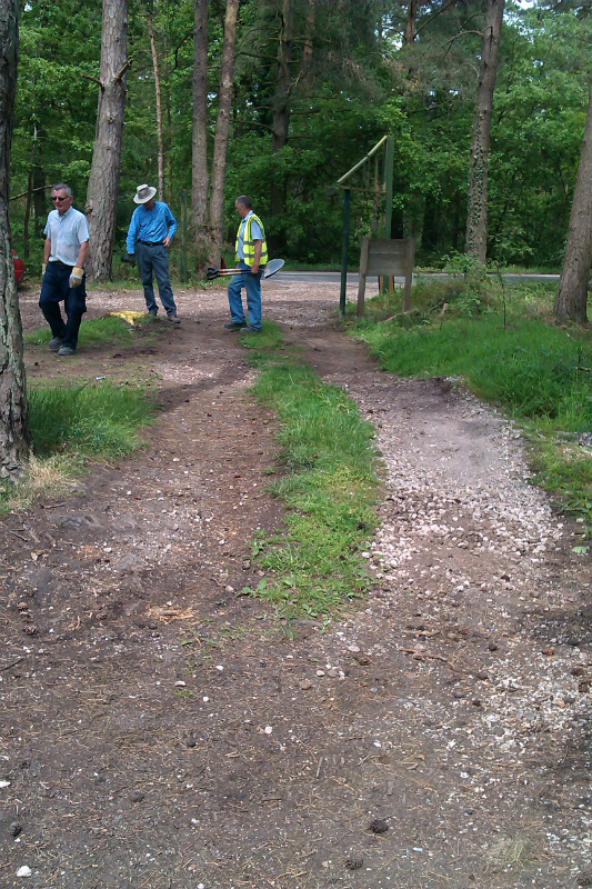 Volunteers check re-installed sign